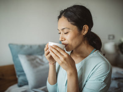Woman drinking herbal tea as part of her daily wellness routine by SuperBonsai