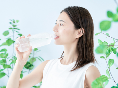 Woman drinking water as part of a healthy liver routine